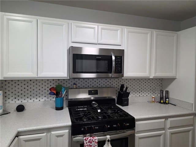 529 S Northern Blvd, Sugar Creek, MO 64054 - kitchen featuring appliances with stainless steel finishes, white cabinetry, backsplash, and light countertops
