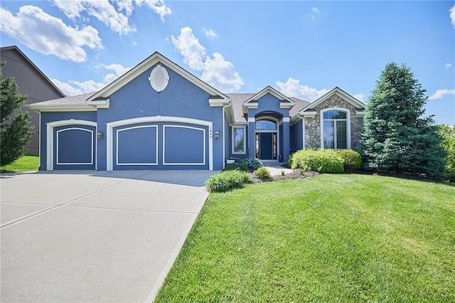 ranch-style house featuring a garage, concrete driveway, a front yard, stone siding, and stucco siding