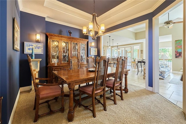 dining room with a chandelier, crown molding, light carpet, baseboards, and a ceiling fan