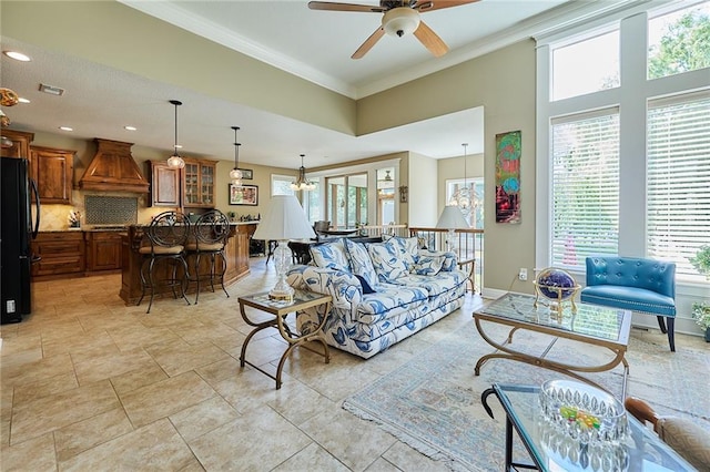 living area featuring ornamental molding, a ceiling fan, recessed lighting, and a chandelier