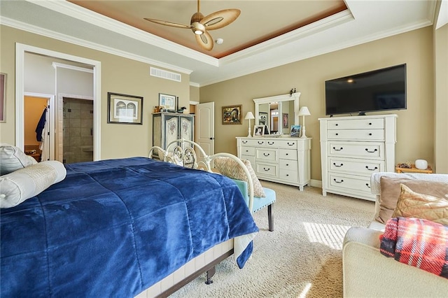 bedroom featuring ornamental molding, light colored carpet, a tray ceiling, and ceiling fan