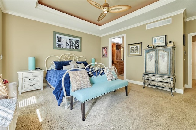 bedroom with light carpet, crown molding, a tray ceiling, baseboards, and ceiling fan