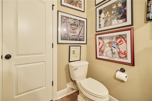 bathroom featuring baseboards, toilet, and tile patterned flooring