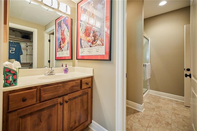 full bath featuring a stall shower, vanity, baseboards, recessed lighting, and tile patterned flooring