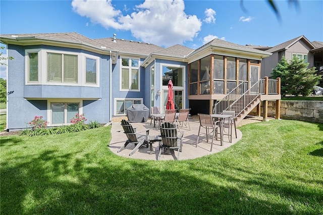 back of house featuring a sunroom, a patio, a yard, and stucco siding