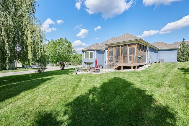 back of property featuring a sunroom, a yard, and a patio