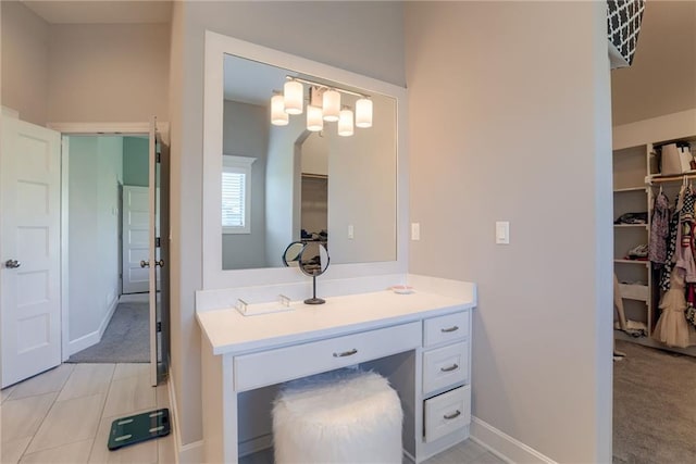 16200 Stearns St, Overland Park, KS 66221 - bathroom with a walk in closet, vanity, and baseboards