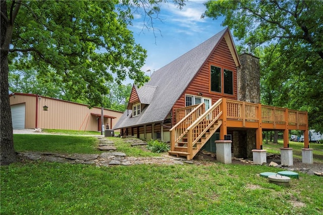 429 SE Lakeside Dr, Lacygne, KS 66040 - back of property with a deck, a yard, a detached garage, stairs, and roof with shingles