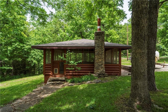 429 SE Lakeside Dr, Lacygne, KS 66040 - view of front facade featuring log veneer siding, a sunroom, and a front lawn