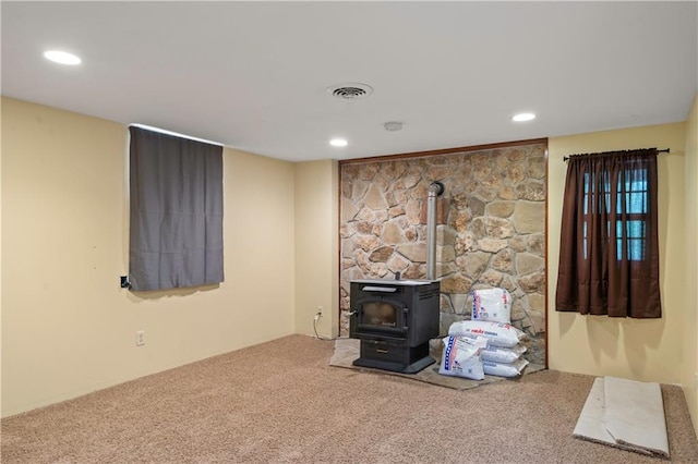 429 SE Lakeside Dr, Lacygne, KS 66040 - unfurnished living room featuring a wood stove, carpet flooring, and recessed lighting