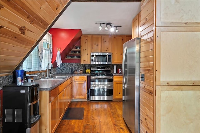 429 SE Lakeside Dr, Lacygne, KS 66040 - kitchen with appliances with stainless steel finishes, a sink, hardwood / wood-style floors, dark countertops, and tasteful backsplash