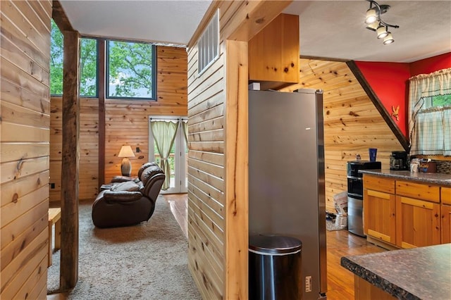 429 SE Lakeside Dr, Lacygne, KS 66040 - kitchen with freestanding refrigerator, wood walls, and dark countertops