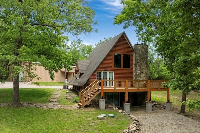 429 SE Lakeside Dr, Lacygne, KS 66040 - rear view of house featuring a wooden deck, driveway, a lawn, stairs, and faux log siding