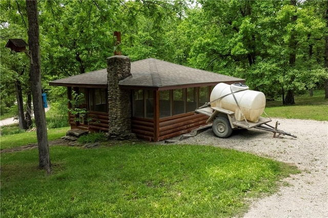 429 SE Lakeside Dr, Lacygne, KS 66040 - view of home's exterior featuring roof with shingles, a chimney, a lawn, and driveway