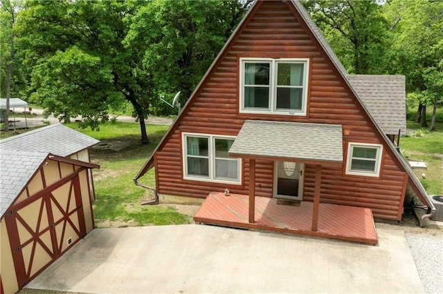 429 SE Lakeside Dr, Lacygne, KS 66040 - rear view of house featuring a shingled roof, an outbuilding, a storage shed, and a deck