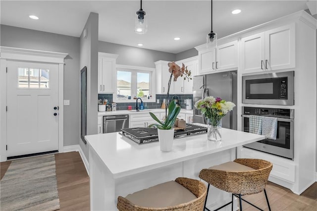 522 NW 110th St, Kansas City, MO 64155 - kitchen with stainless steel appliances, white cabinets, decorative backsplash, light wood finished floors, and recessed lighting