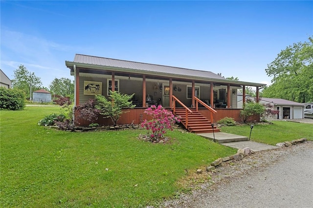 336 SE Zack Wheat Dr, Polo, MO 64671 - view of front facade with covered porch, a front yard, metal roof, and a garage