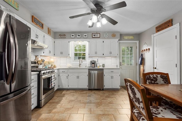 336 SE Zack Wheat Dr, Polo, MO 64671 - kitchen featuring stainless steel appliances, under cabinet range hood, ceiling fan, a sink, and backsplash