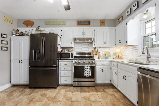 336 SE Zack Wheat Dr, Polo, MO 64671 - kitchen with stainless steel appliances, a sink, white cabinets, and under cabinet range hood