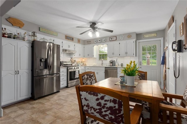 336 SE Zack Wheat Dr, Polo, MO 64671 - kitchen featuring stainless steel appliances, a ceiling fan, under cabinet range hood, backsplash, and white cabinets