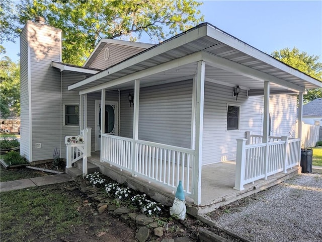 528 W Ashland St, Nevada, MO 64772 - view of front facade featuring a porch and a chimney