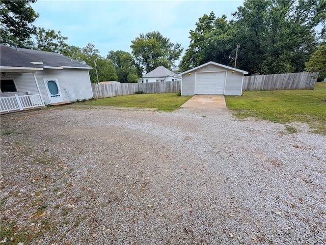 528 W Ashland St, Nevada, MO 64772 - view of yard featuring concrete driveway, an outbuilding, and a garage