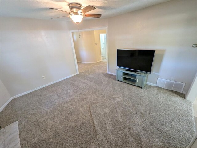 528 W Ashland St, Nevada, MO 64772 - unfurnished living room featuring ceiling fan, carpet, baseboards, and a textured ceiling