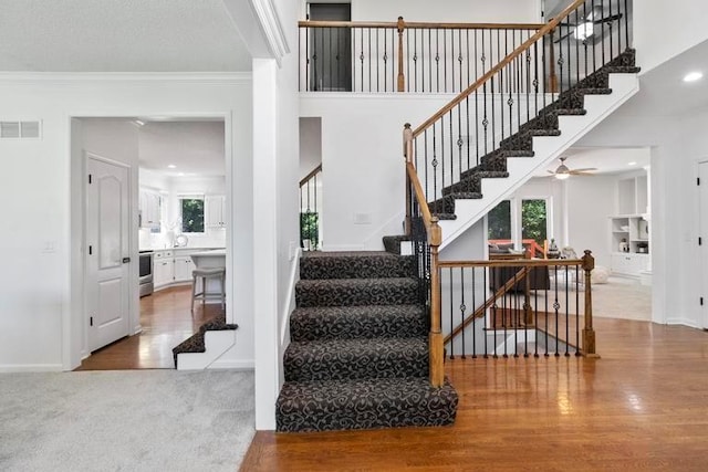 4612 Roberts St, Shawnee, KS 66226 - staircase with crown molding, wood finished floors, and healthy amount of natural light