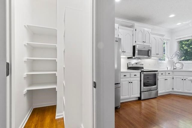4612 Roberts St, Shawnee, KS 66226 - kitchen featuring stainless steel appliances, dark wood-style floors, white cabinetry, backsplash, and light countertops