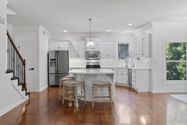 4612 Roberts St, Shawnee, KS 66226 - kitchen featuring appliances with stainless steel finishes, white cabinetry, light countertops, crown molding, and recessed lighting