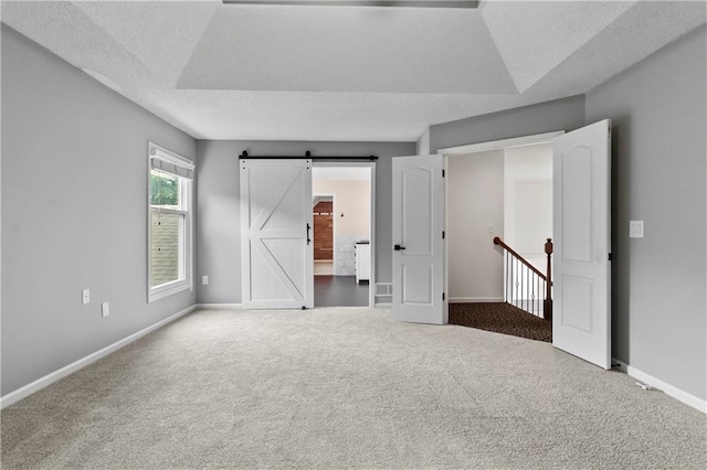 4612 Roberts St, Shawnee, KS 66226 - unfurnished bedroom featuring carpet floors, a barn door, and a textured ceiling