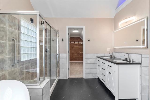 4612 Roberts St, Shawnee, KS 66226 - bathroom with tile walls, double vanity, a shower stall, tile patterned flooring, and a wainscoted wall