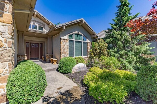 26650 W 100th Pl, Olathe, KS 66061 - property entrance featuring stone siding, a tile roof, and stucco siding