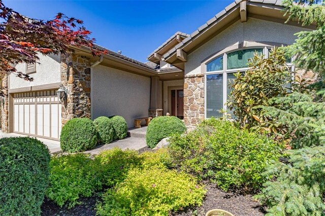 26650 W 100th Pl, Olathe, KS 66061 - view of exterior entry with stone siding, stucco siding, and an attached garage