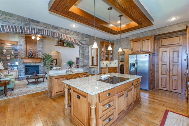 26650 W 100th Pl, Olathe, KS 66061 - kitchen featuring stainless steel fridge, a center island, light wood finished floors, and a large fireplace