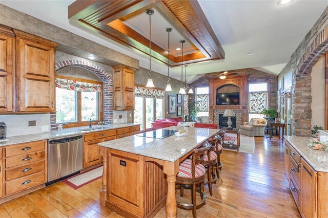 26650 W 100th Pl, Olathe, KS 66061 - kitchen featuring stainless steel dishwasher, black electric stovetop, light wood-type flooring, a raised ceiling, and lofted ceiling