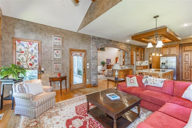 26650 W 100th Pl, Olathe, KS 66061 - living area featuring arched walkways, light wood-style floors, a chandelier, lofted ceiling, and recessed lighting