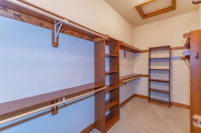 26650 W 100th Pl, Olathe, KS 66061 - walk in closet featuring light carpet, built in desk, and attic access
