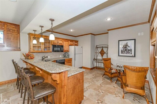 26650 W 100th Pl, Olathe, KS 66061 - kitchen featuring black appliances, brown cabinets, baseboards, stone tile floors, and ornamental molding