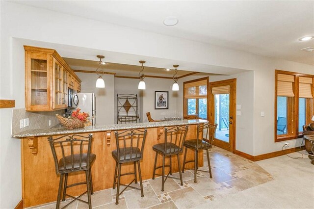 26650 W 100th Pl, Olathe, KS 66061 - kitchen with freestanding refrigerator, glass insert cabinets, a peninsula, light carpet, and brown cabinets