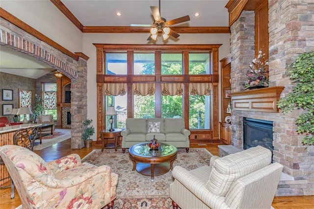 26650 W 100th Pl, Olathe, KS 66061 - living area with a stone fireplace, plenty of natural light, ceiling fan, wood finished floors, and ornamental molding