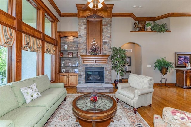 26650 W 100th Pl, Olathe, KS 66061 - living area featuring plenty of natural light, wood finished floors, ornamental molding, a stone fireplace, and baseboards