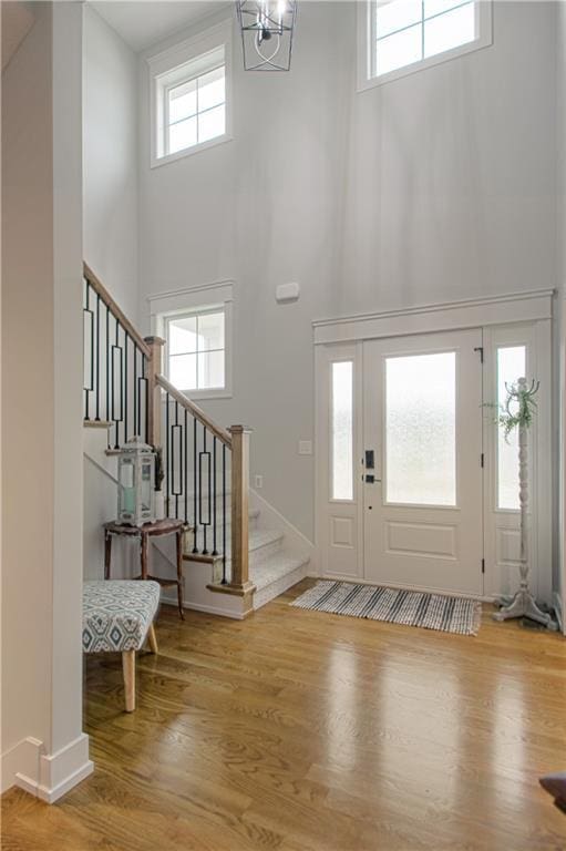 2241 Foxtail Dr, Kearney, MO 64060 - entryway featuring a high ceiling, stairs, wood finished floors, baseboards, and a chandelier
