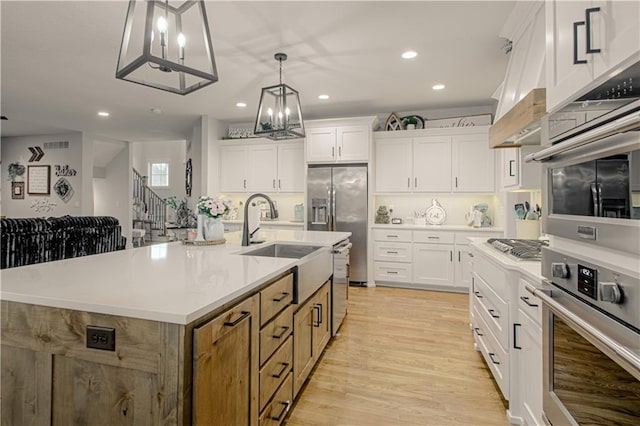 2241 Foxtail Dr, Kearney, MO 64060 - kitchen featuring a sink, white cabinets, recessed lighting, pendant lighting, and light wood finished floors