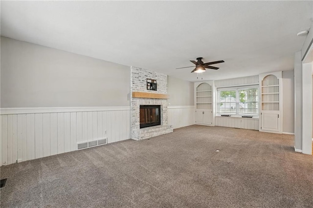 15642 W 146th Ter, Olathe, KS 66062 - unfurnished living room featuring ceiling fan, a wainscoted wall, a fireplace, and carpet floors