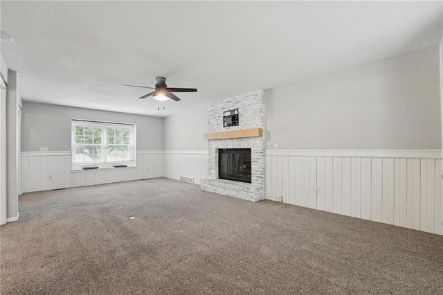 15642 W 146th Ter, Olathe, KS 66062 - unfurnished living room featuring a wainscoted wall, ceiling fan, a brick fireplace, and carpet