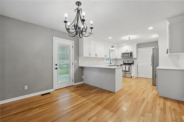 15642 W 146th Ter, Olathe, KS 66062 - kitchen with stainless steel appliances, a peninsula, light wood-style floors, tasteful backsplash, and light countertops