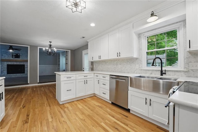 15642 W 146th Ter, Olathe, KS 66062 - kitchen featuring stainless steel dishwasher, a sink, a peninsula, light wood-type flooring, and a chandelier