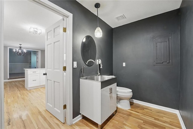 15642 W 146th Ter, Olathe, KS 66062 - bathroom with wood finished floors, a chandelier, toilet, vanity, and baseboards
