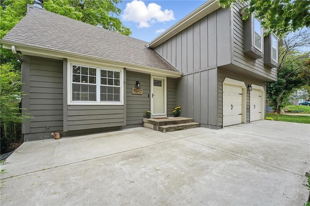15642 W 146th Ter, Olathe, KS 66062 - view of front of house with board and batten siding, driveway, a garage, a chimney, and a shingled roof
